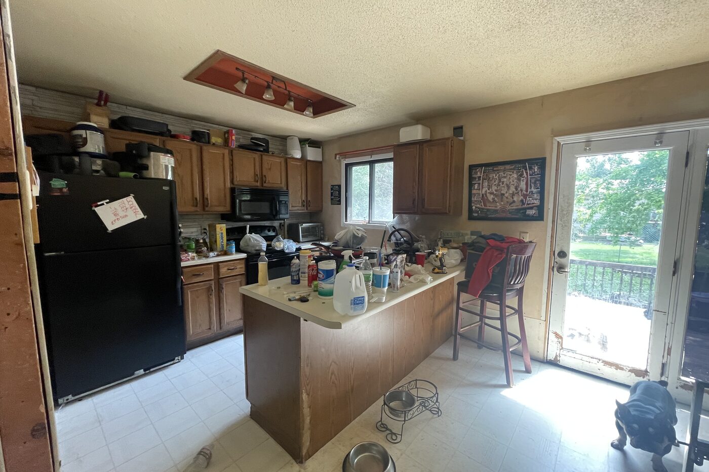 A kitchen in a house we bought full of belongings before All Things Home worked on it